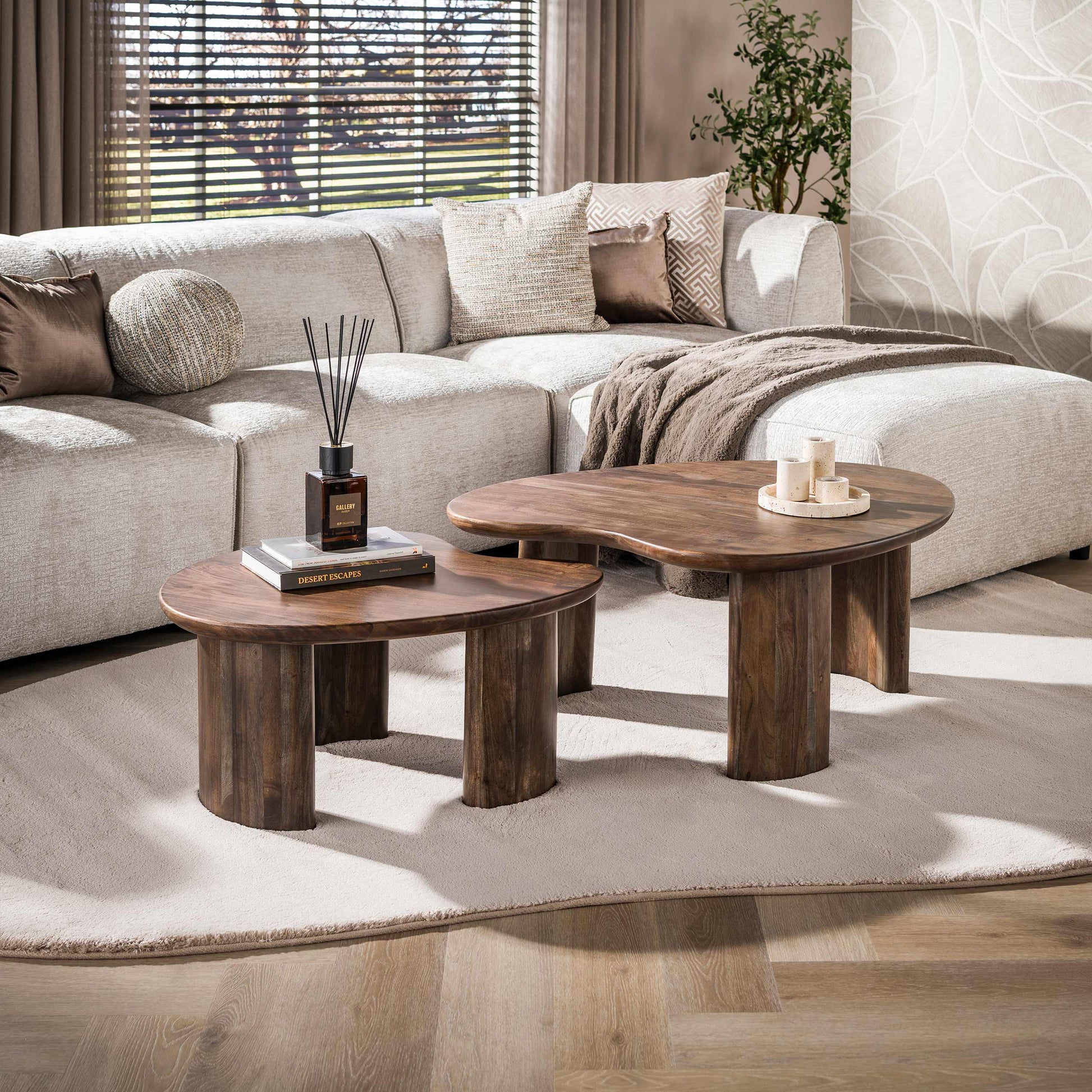 Helles Couchtisch-Set Mova mit modernem Design, bestehend aus mehreren Tischen in einem stilvollen Wohnzimmer.
