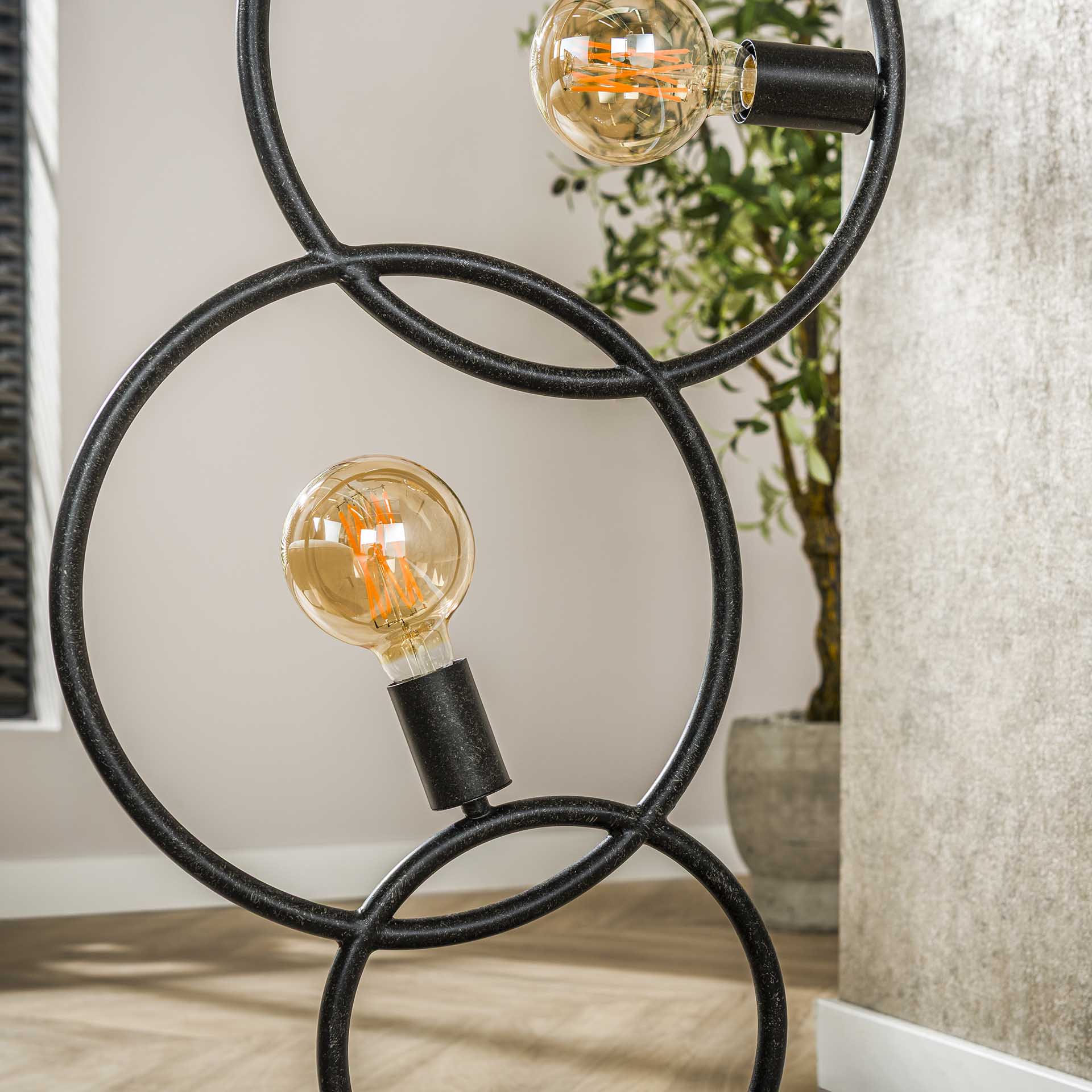 Moderne Loop Stehlampe von lefurn.de mit eleganter, geschwungener Gestaltung und warmem Licht in einem stilvollen Wohnzimmer.