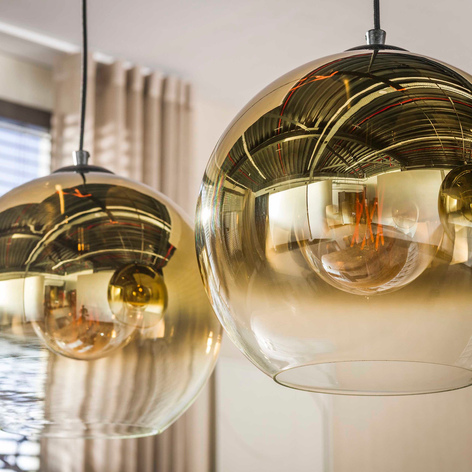 Hängelampe Bubble Shaded Gold mit goldener Oberfläche und kugelähnlichem Lampenschirm, stilvoll im modernen Wohnzimmer.